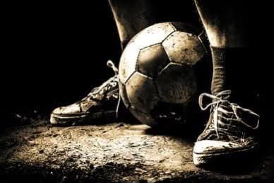Sports boots and a ball on the training ground