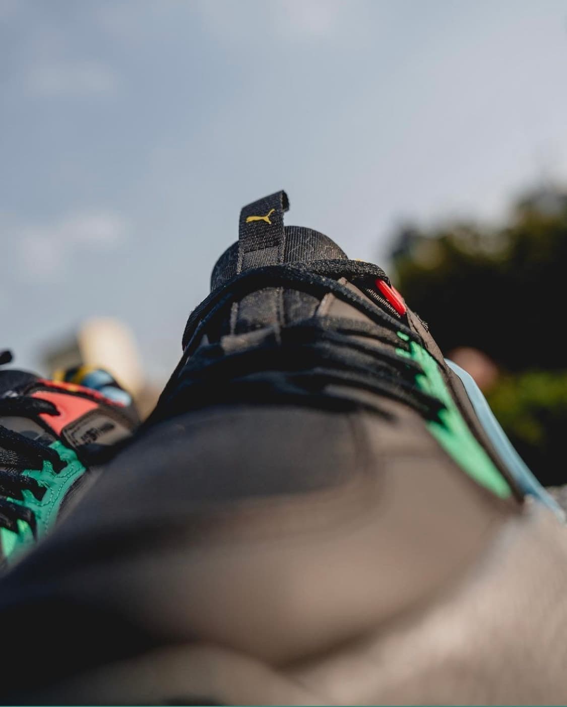 Close-up of the heel of a colourful sneaker against a soft sky